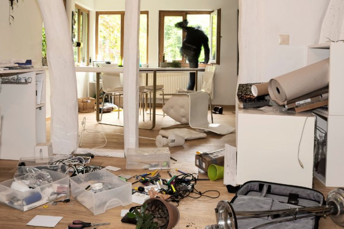 burglar leaving home through a window; the room is trashed