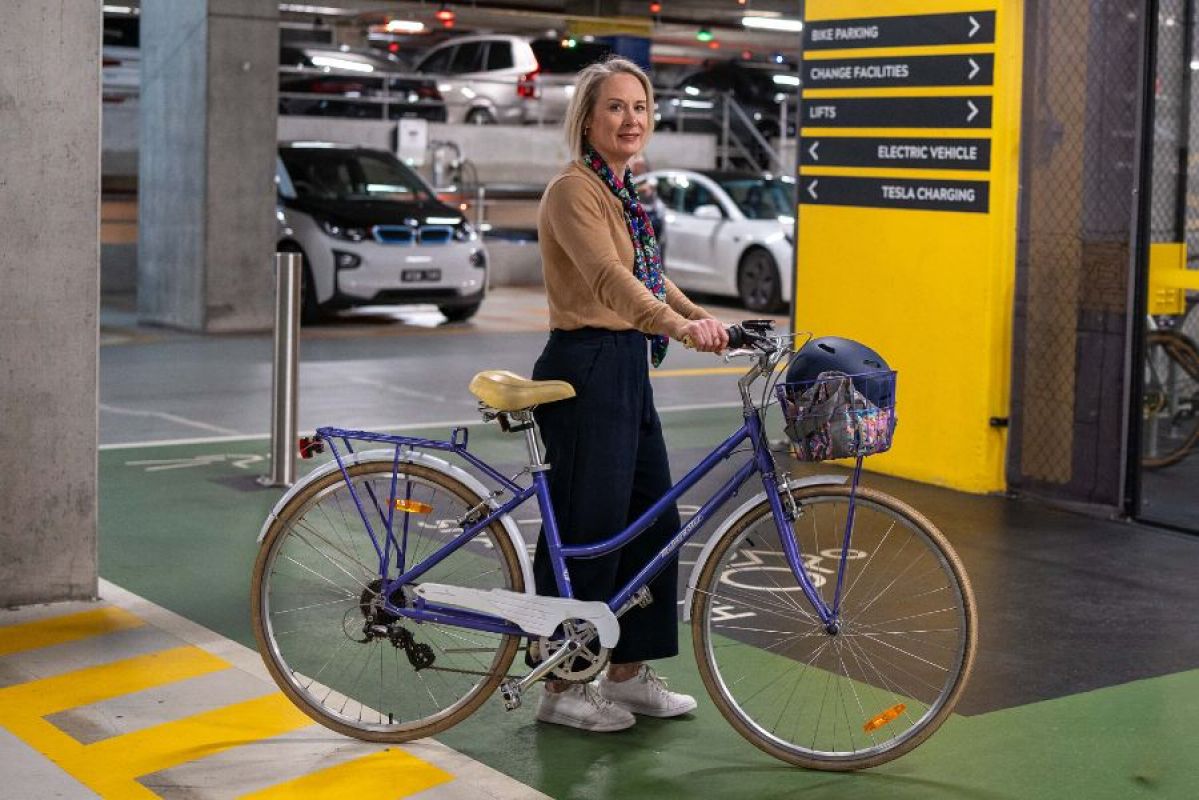 woman walking her bike in end-of-trip work facility
