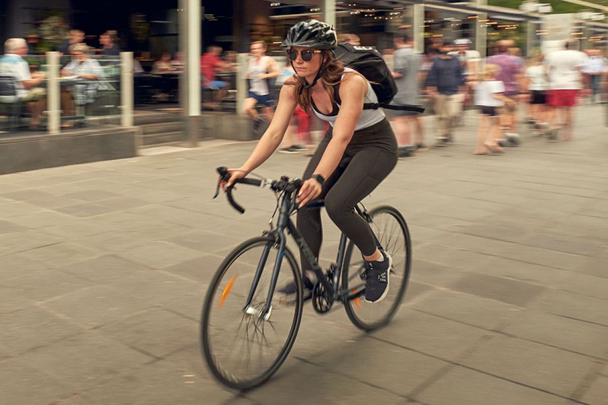 A woman wearing a helmet as she cycles through Southbank in Melbourne