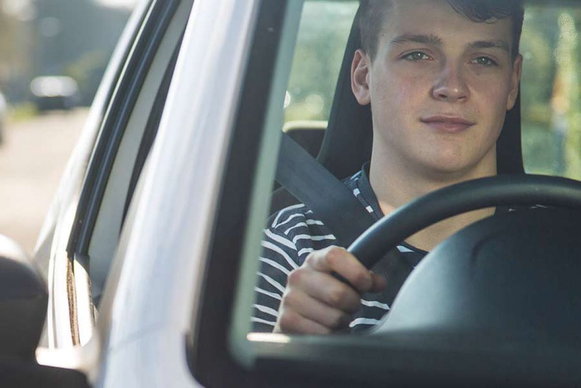 Close up of young male driving car