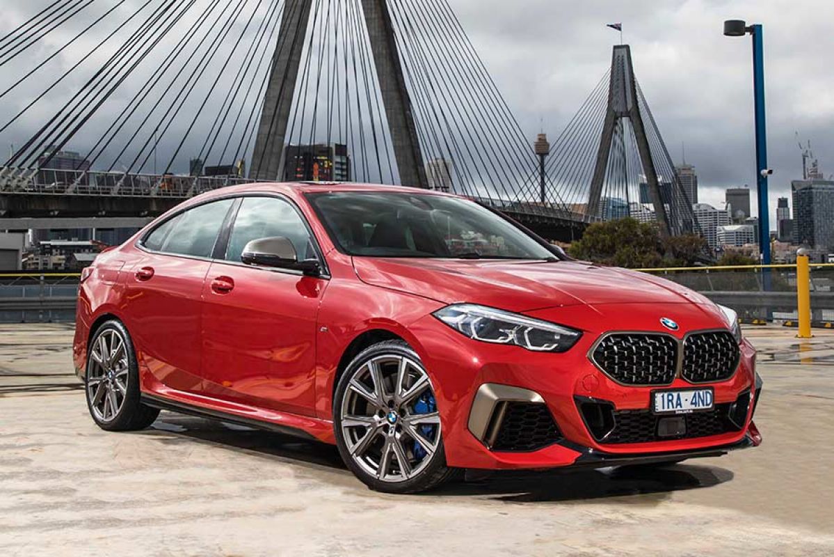 A red BMW M235i xDrive Gran Coupe car parked in front of the Anzac Bridge in Syndey, NSW