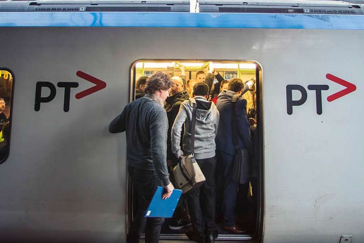 Packed train with people trying to get in before the door closes.