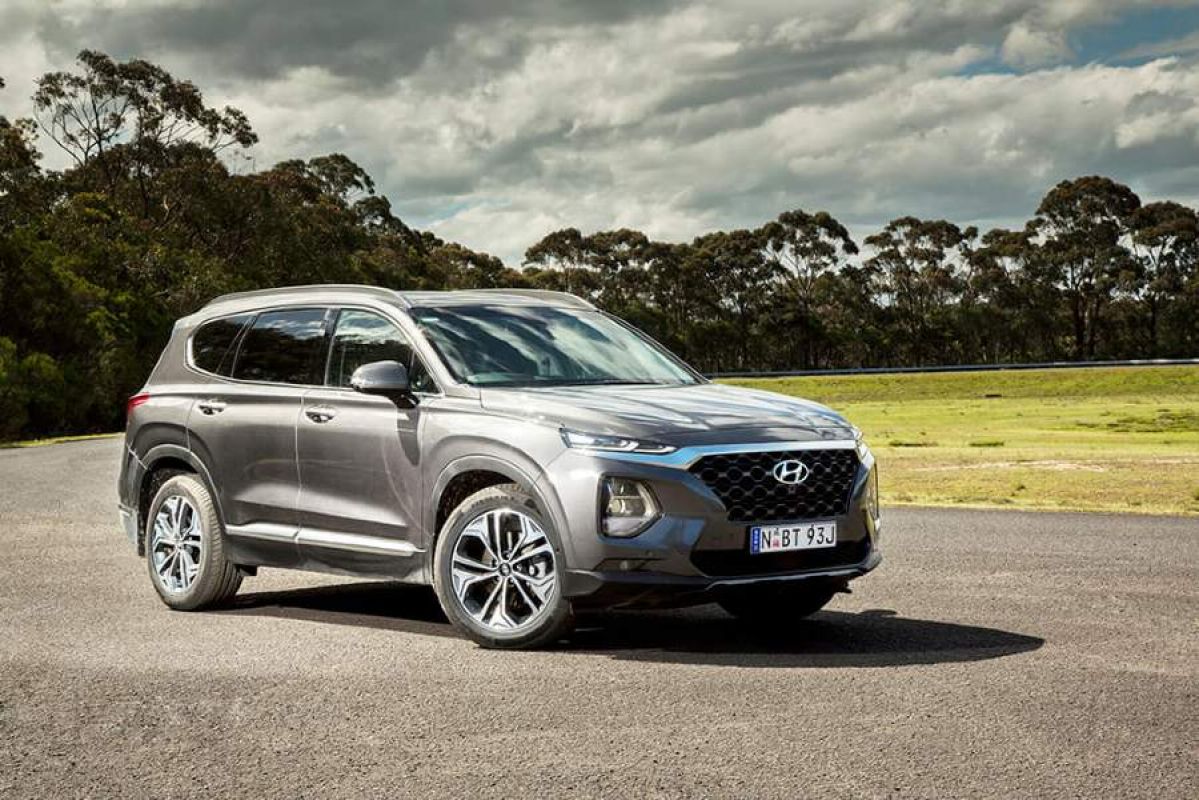 silver hyundai santafe parked on a road next to grass