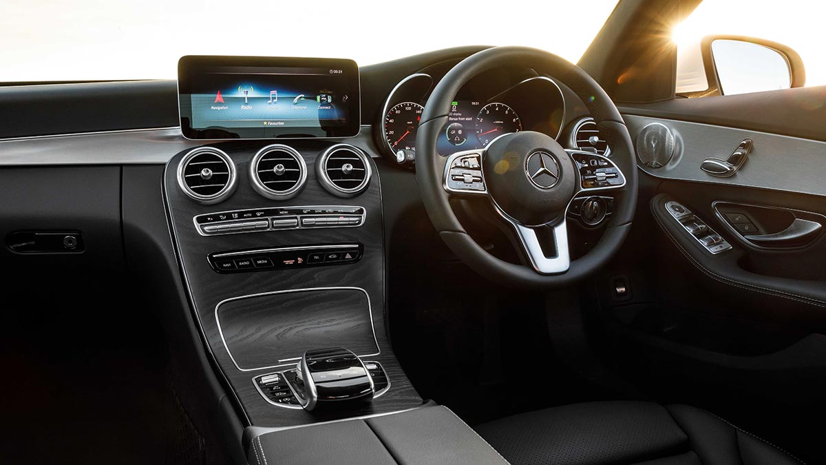 Black interior of the Mercedes-Benz C 200 showing the centre console and steering wheel