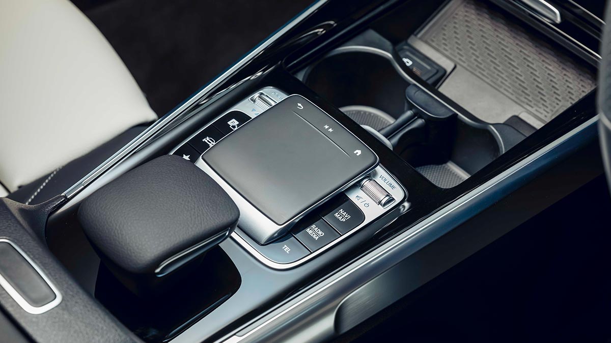 Close up of the centre console inside the Mercedes-Benz GLB250 2020 showing two cup holders, a screen and the gear shifter