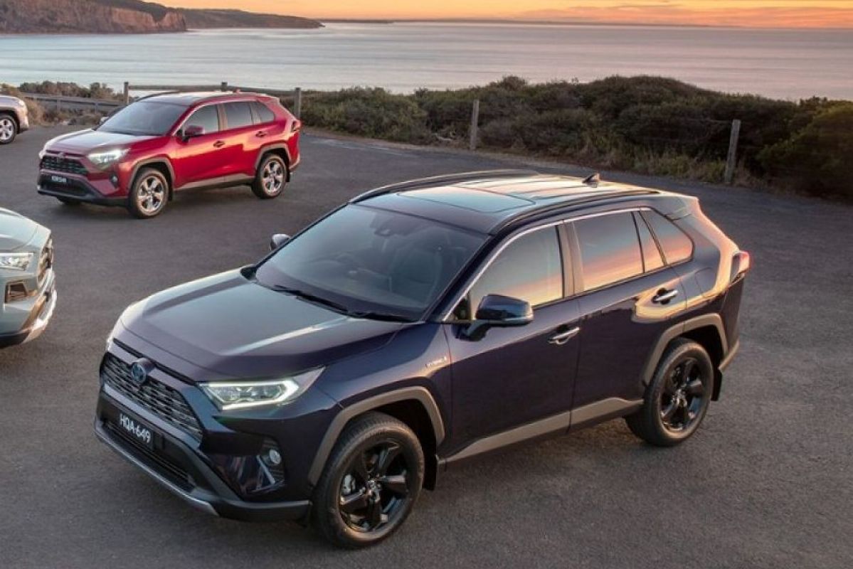 blue toyota rav4 gxl hybrid in a parking area next to the beach at sunset