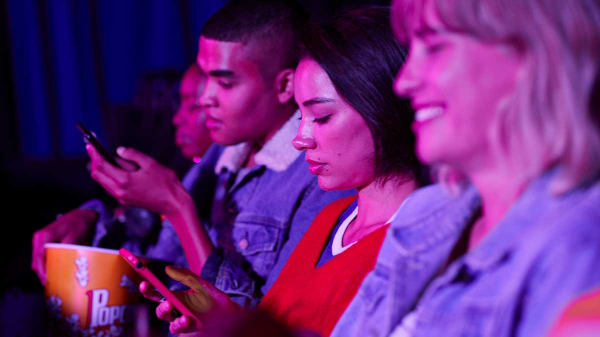 Couple texting in a cinema