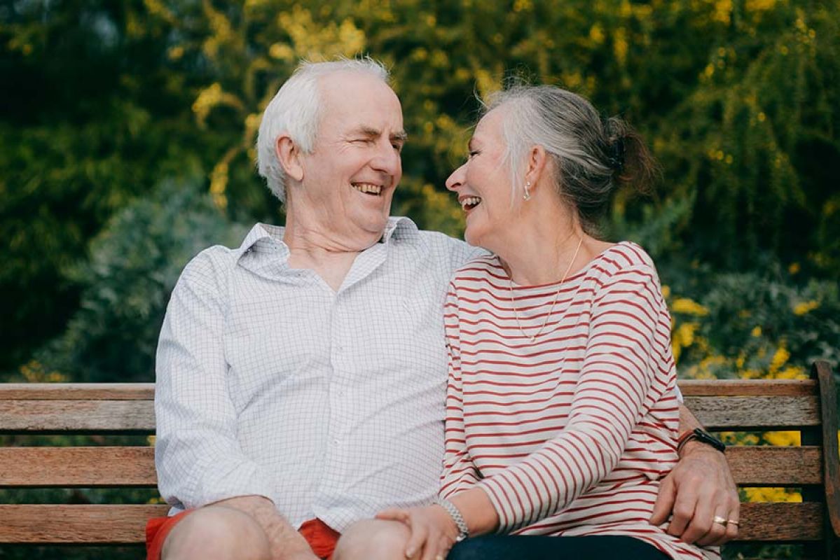 senior couple on their apartment's balcony smiling together