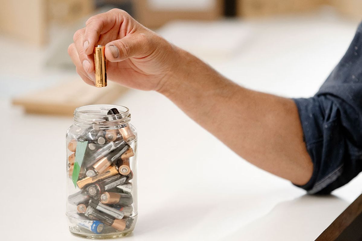 Close-up of hands holding different types of batteries