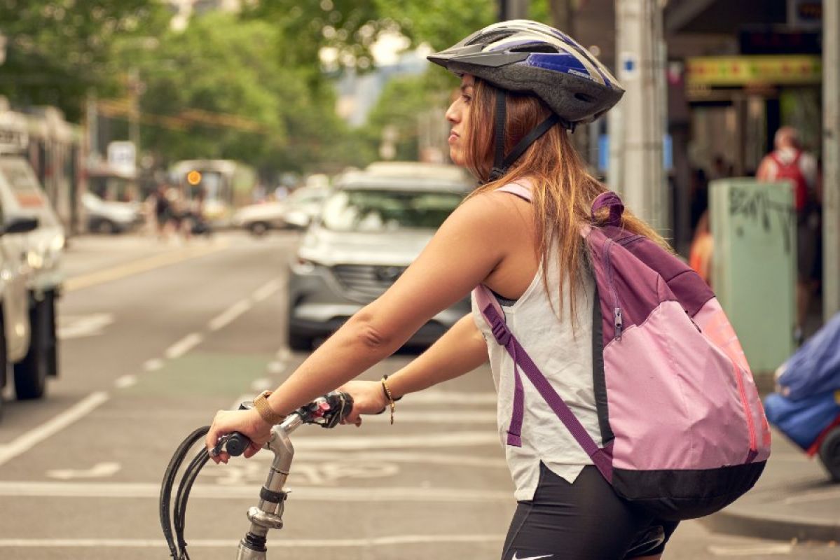 A woman on a bike waiting to turn at an intersection in the Melbourne CBD