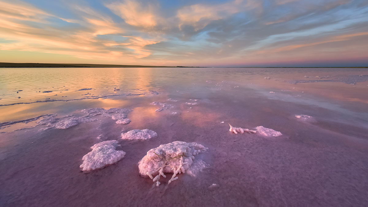 Pink and blue salty water in Lake Tyrrell with blue and yellow sky