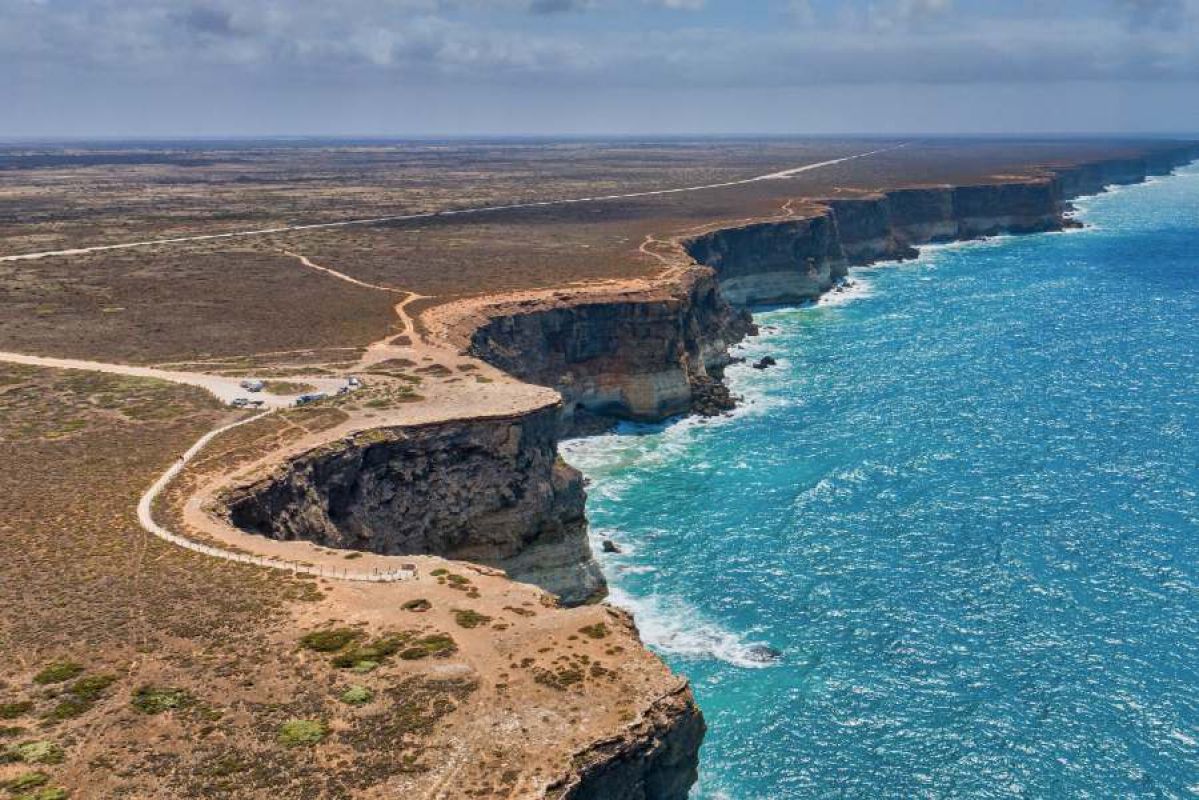 road winding along sea cliffs with blue ocean below