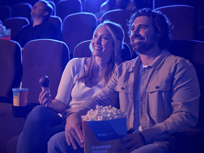 Couple watching a movie together with choc tops and popcorn