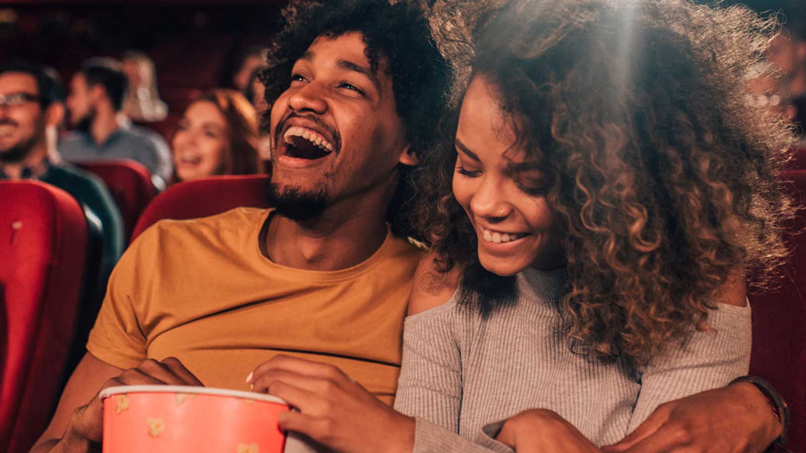 Couple laughing together at the movies.