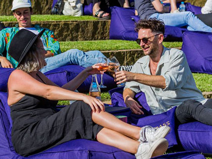 Man and woman reclining on beanbags with wine