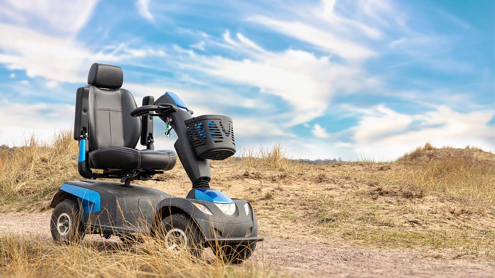 A blue mobility scooter parked in a field.