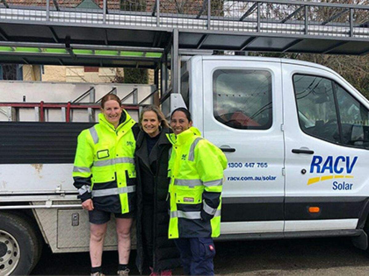 Mel, Tracey and Shaynna on set of Country Home Rescue, standing in front of a RACV Solar truck filled with solar panelling. 