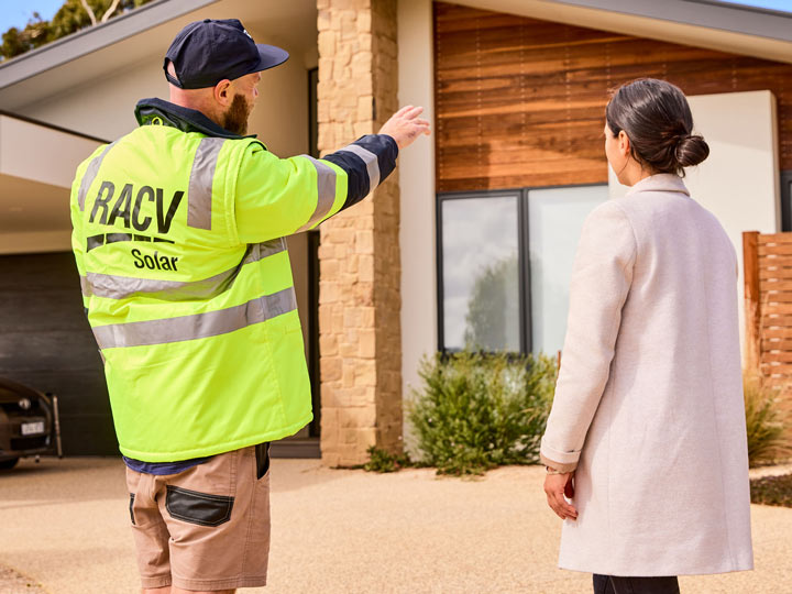 RACV solar installer and RACV customer talking in front of a house. 