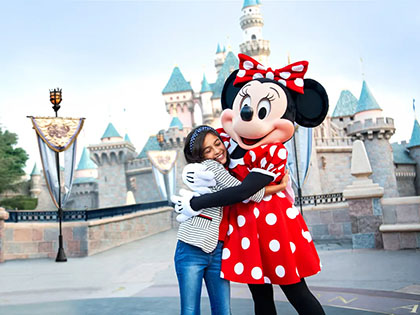 Girl hugging Minnie Mouse at Disneyland.