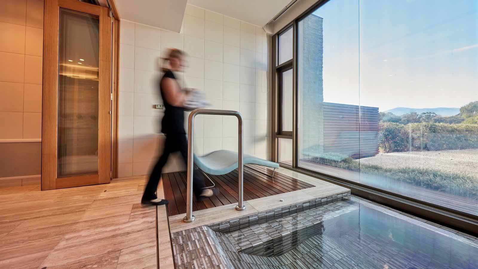 An employee of the Healesville One Spa preparing a treatment room for use.