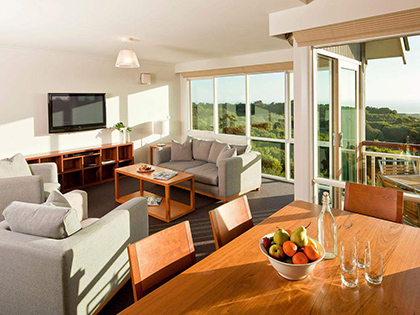 Ocean view villa at RACV Cape Schanck Resort, featuring couches, dining table and chairs.