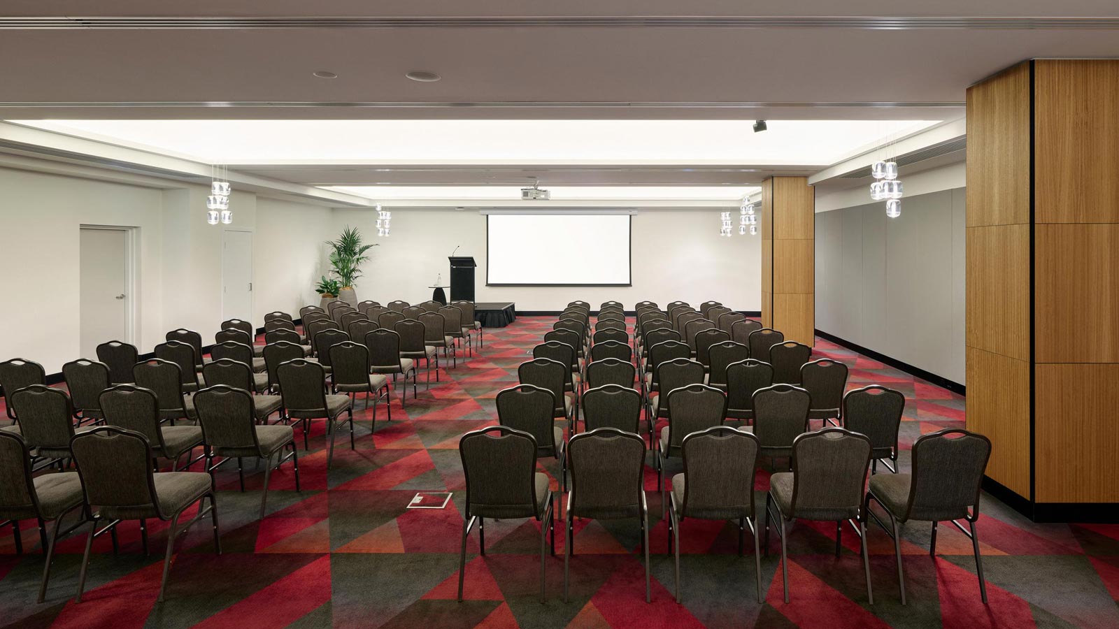 Conference room set up with a projector screen and podium.