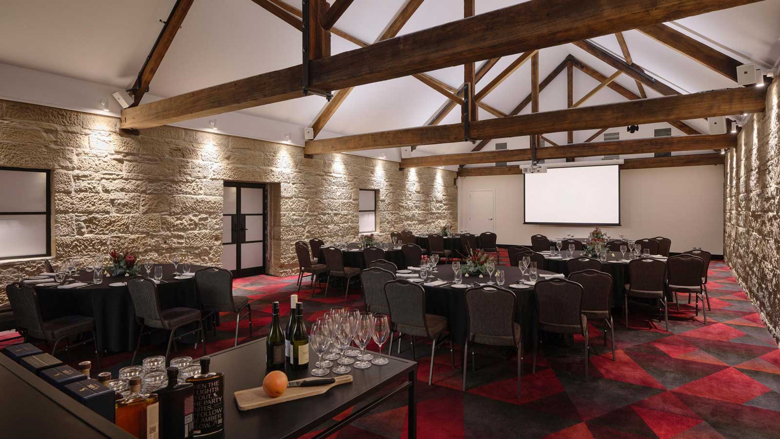 The Stables room set up for dinner service with a bar. 