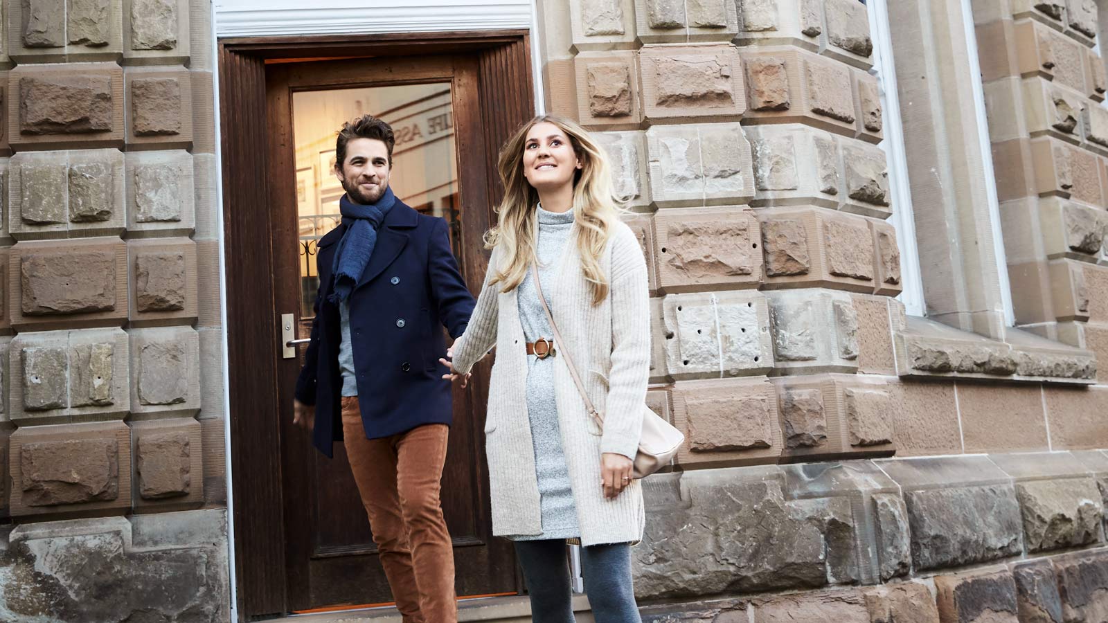 Couple holding hands and smiling just outside the front door of RACV Hobart Hotel's Cascade on Collins bar.