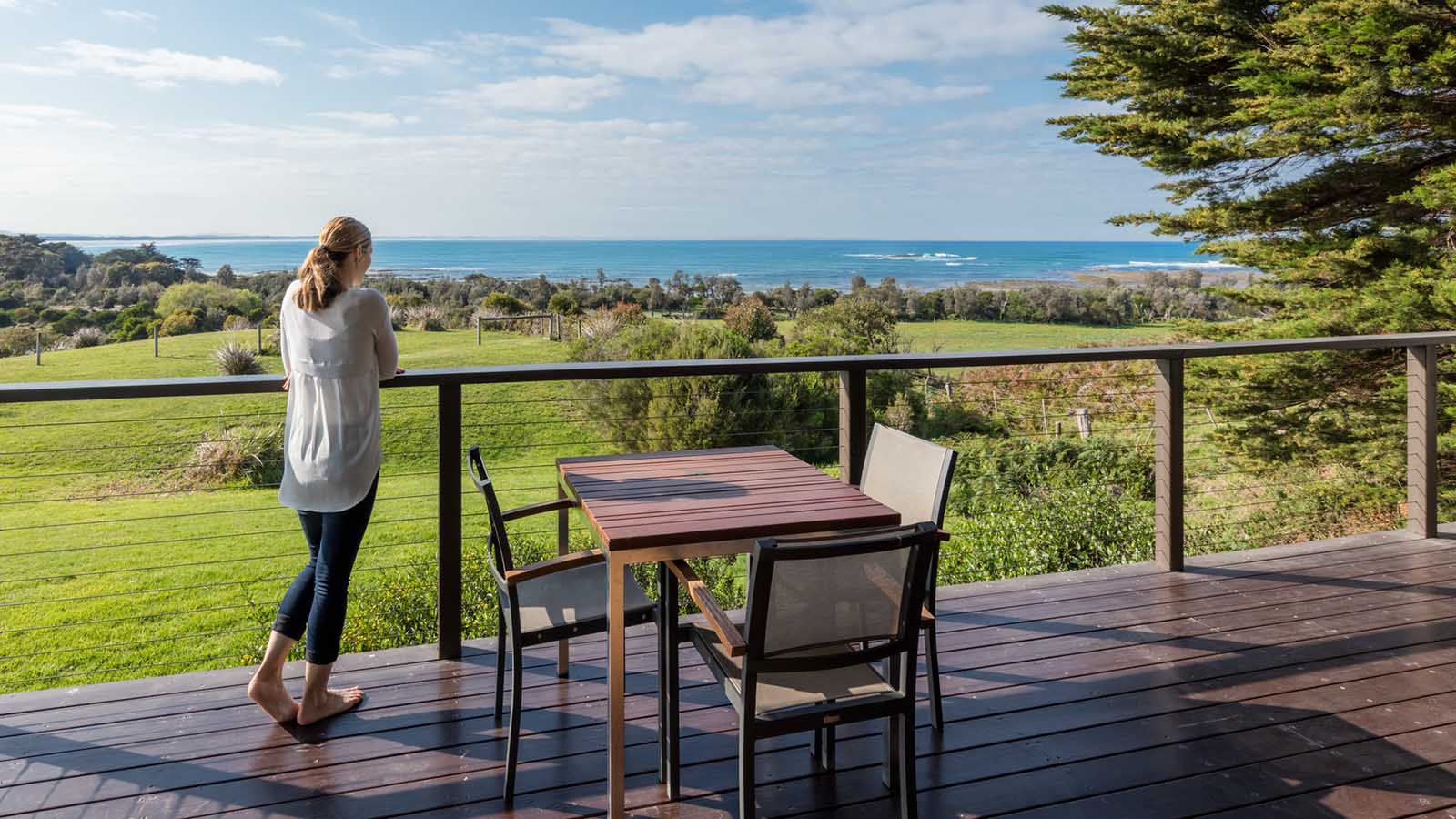 Woman standing on a balcony and looking at the view at RACV Inverloch resort accommodation.