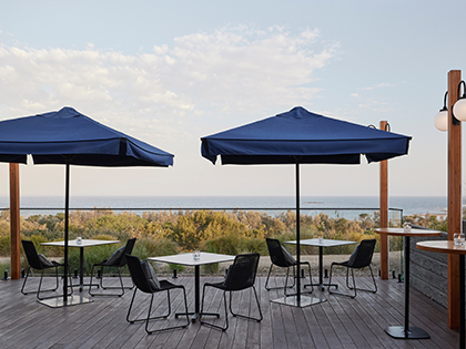 Outdoor dining deck area at RACV Inverloch Resort, featuring tables and chairs facing the beach.