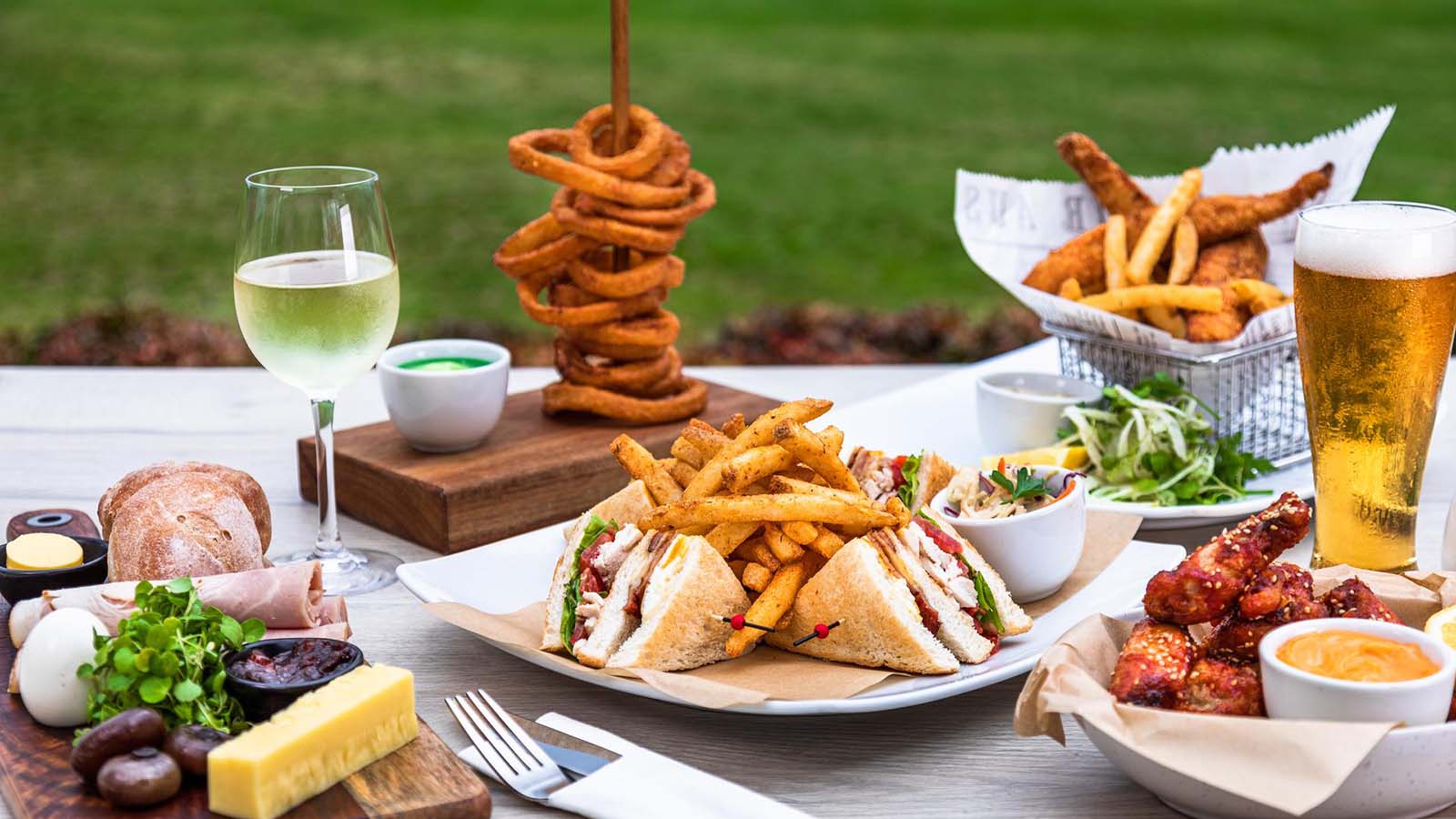 Table outdoors featuring a variety of RACV Royal Pines Tees' Clubhouse menu.