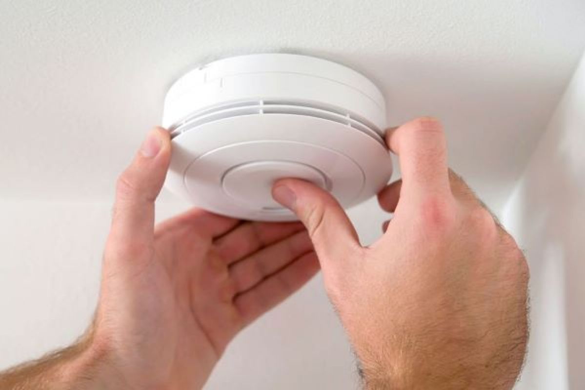 Person checks smoke alarm