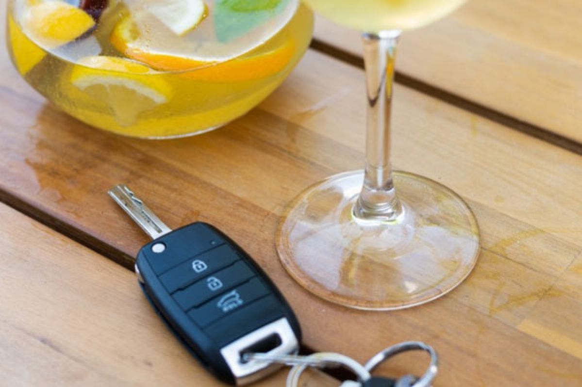 Car keys alongside alcoholic beverage