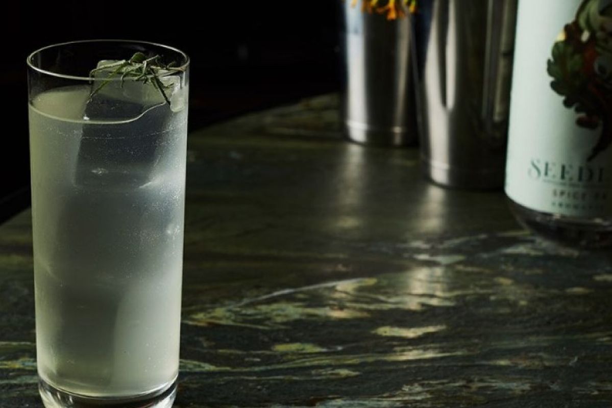 cloudy beverage in a clear glass with ice on a marble table