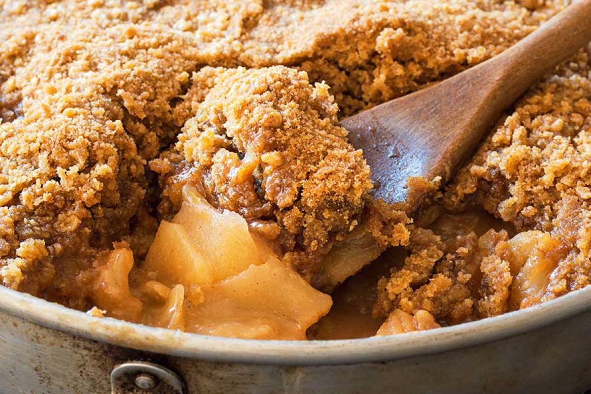 spoonful of apple crumble from a porcelain dish