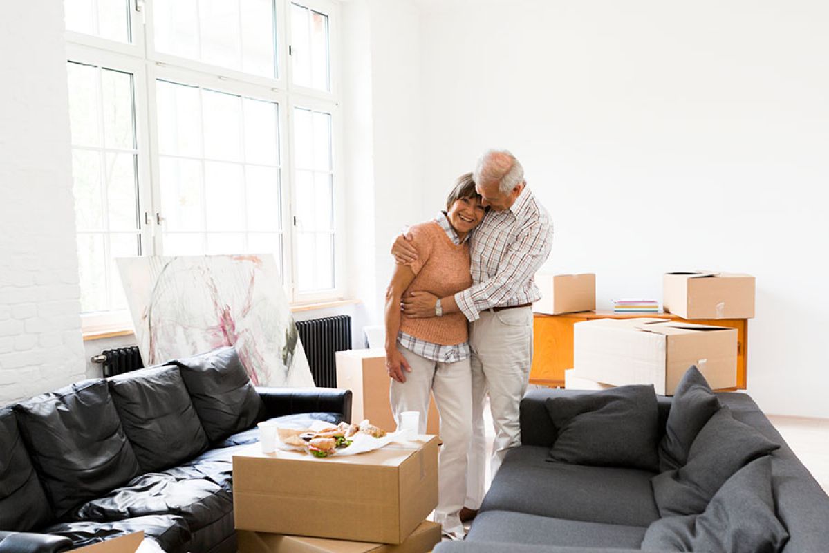 Retired couple relaxing after unpacking contents after downsizing