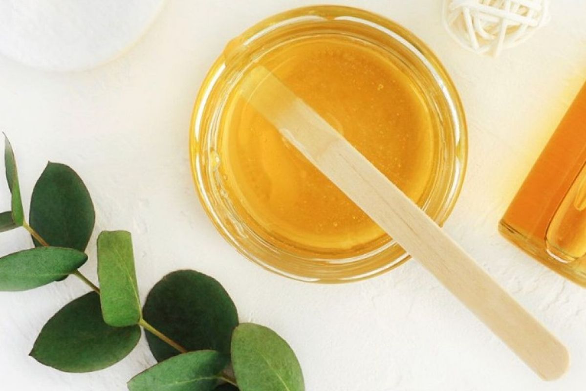 wax in a jar with a spatula and leaves