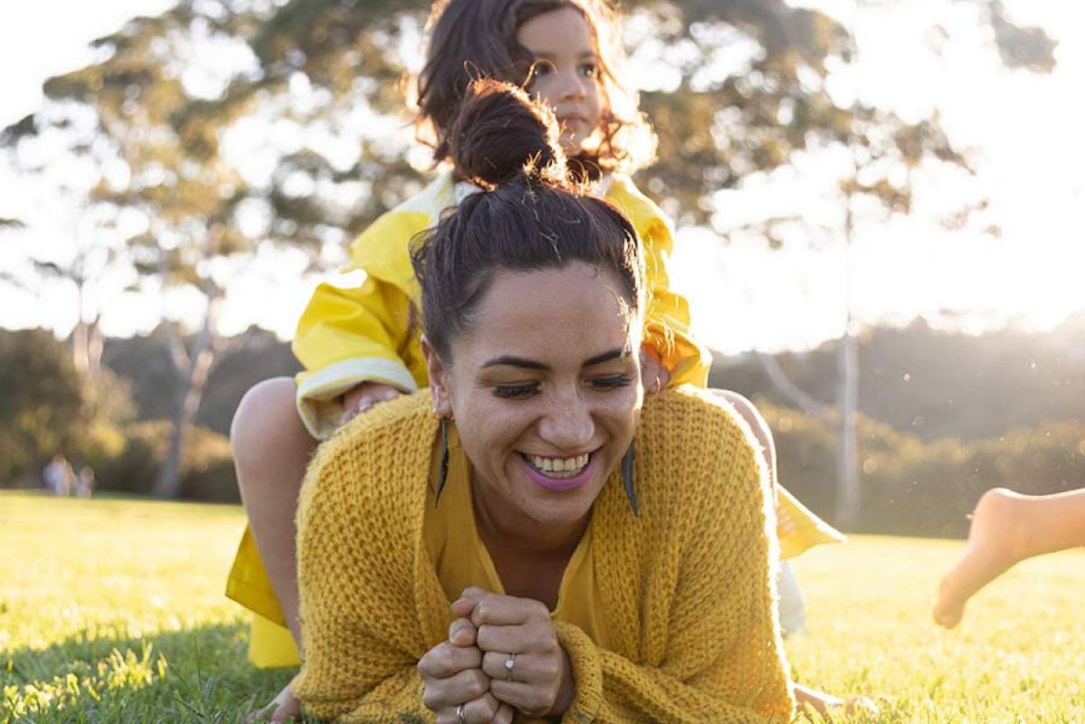 Woman playing in grass with kids