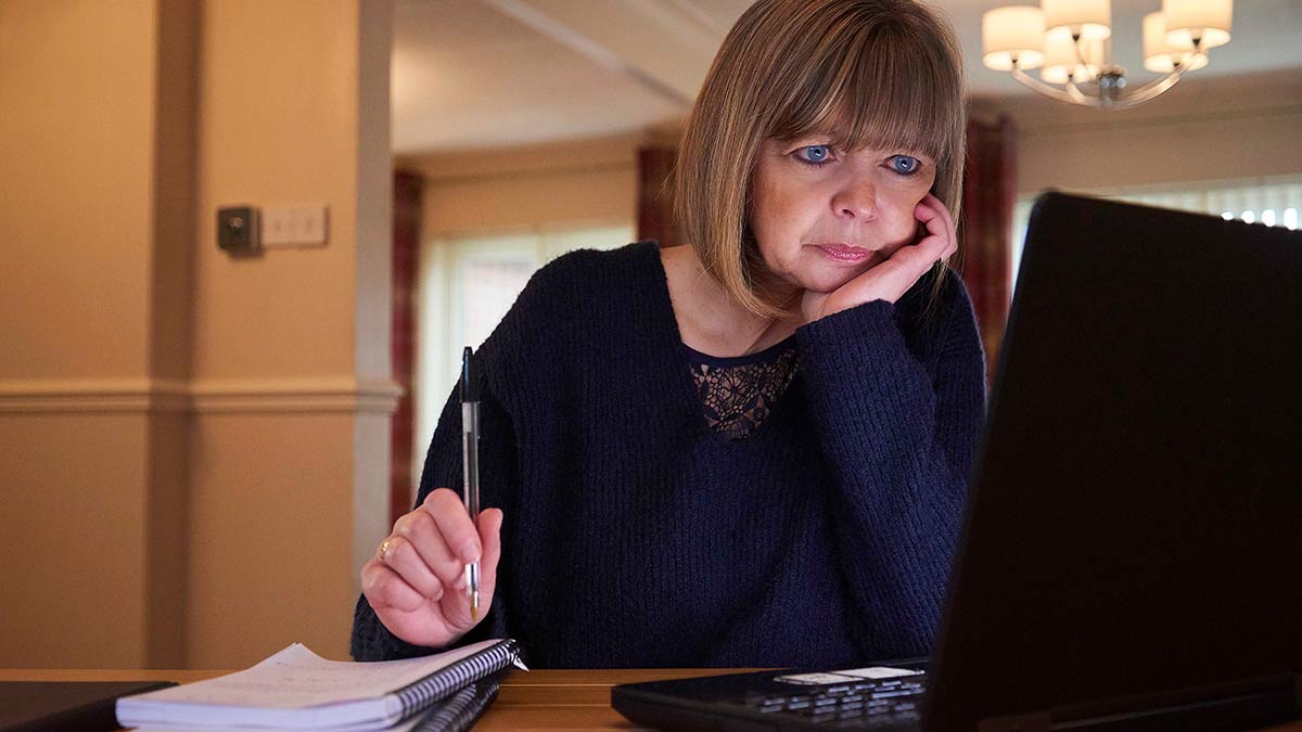 Woman pondering in front of laptop