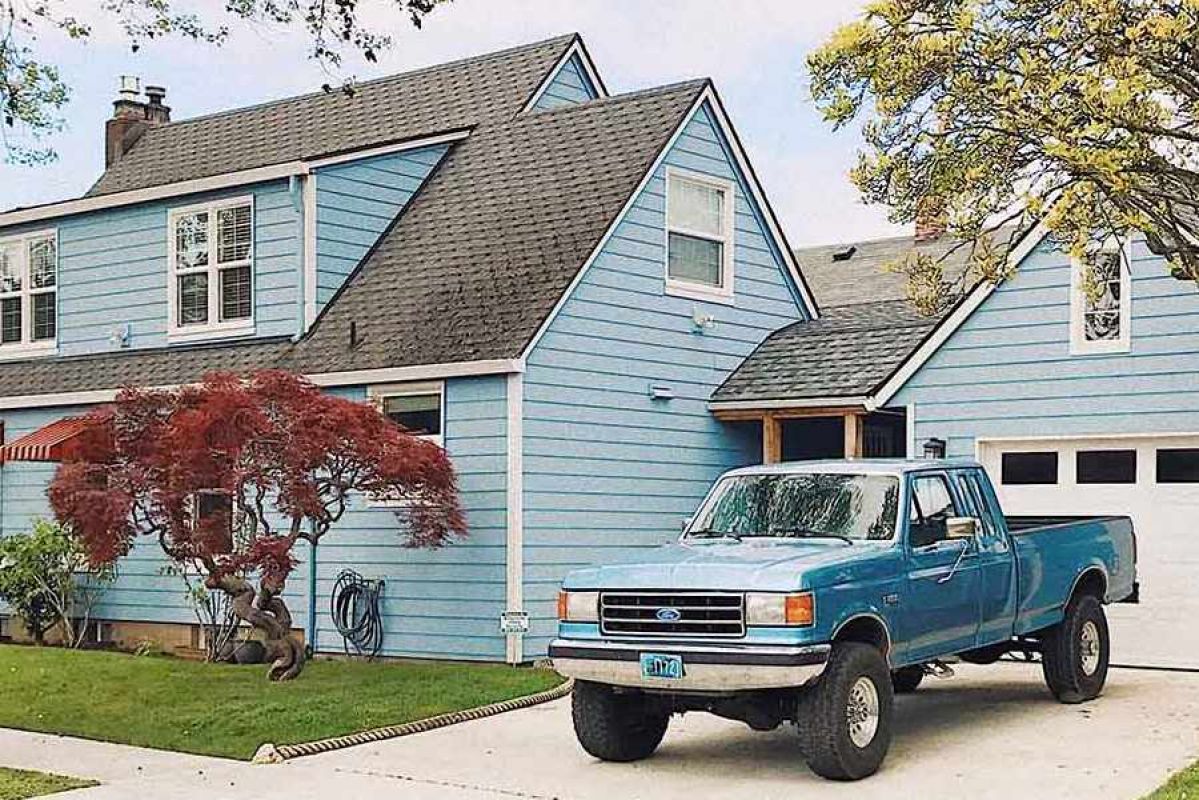 blue ford vehicle parked in driveway of blue house