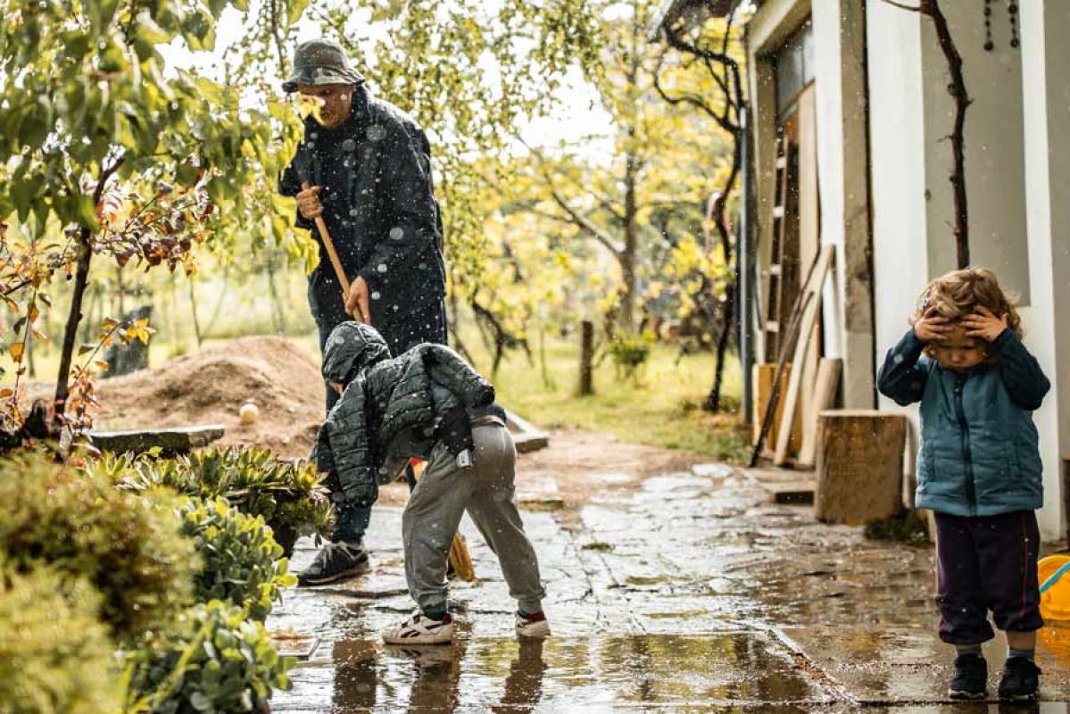 father with children cleaning up their house after a flood