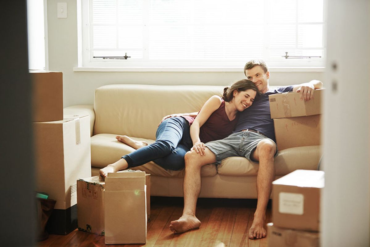 couple sitting on couch surrounded by boxes