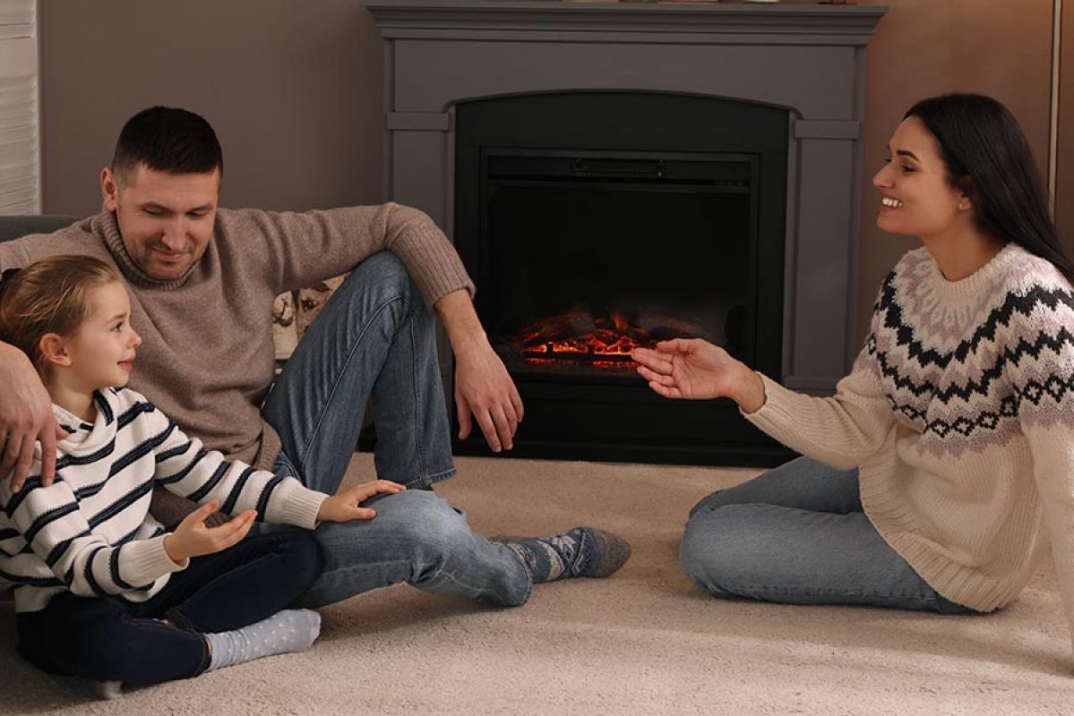 family sitting by fireplace in home