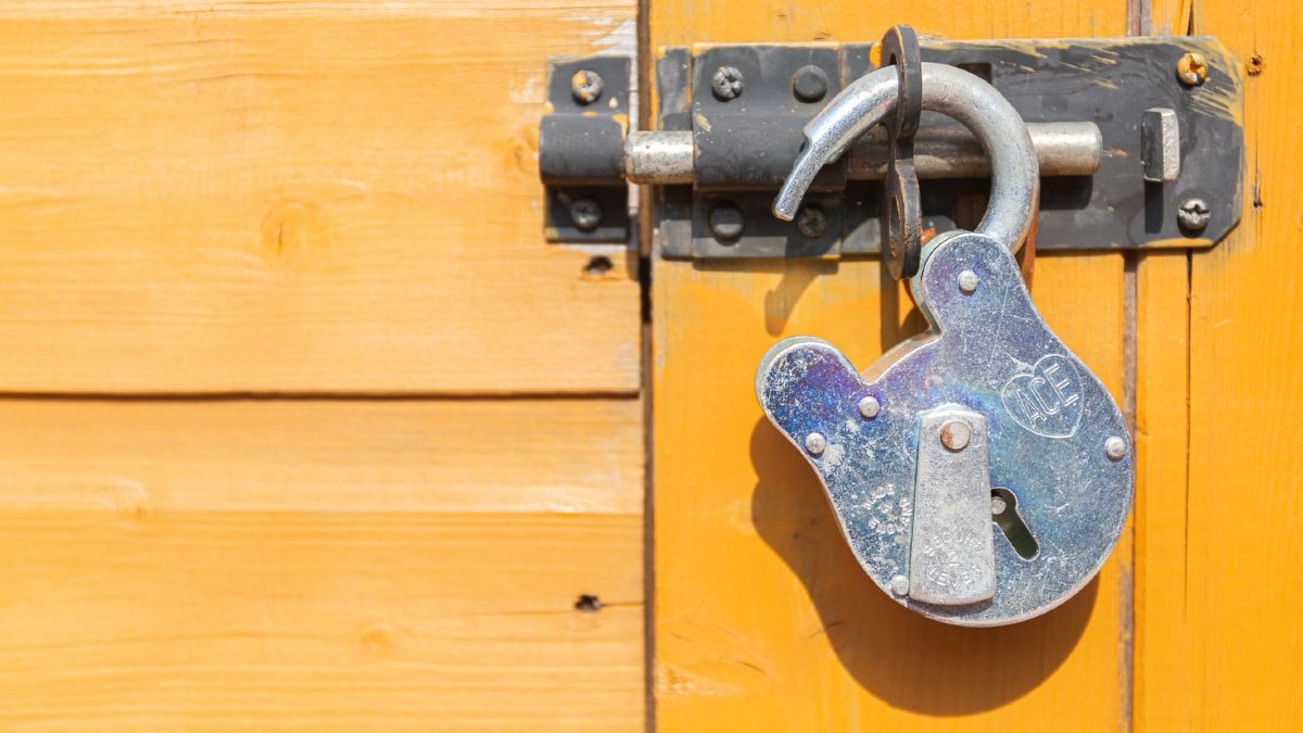 padlock attached to lock on yellow door