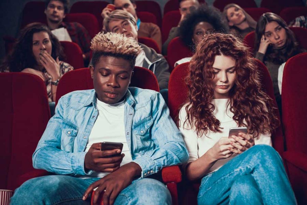 Couple texting in the cinema