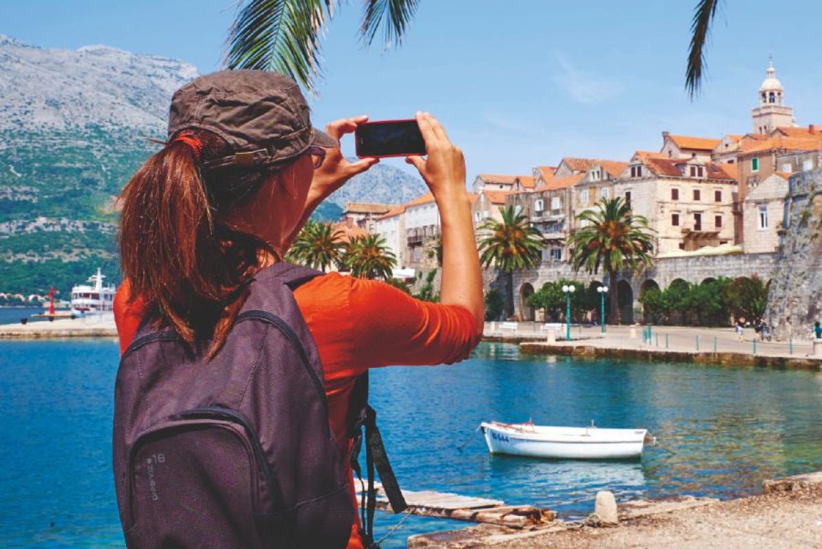 A woman taking a photo of Korcula Island in Croatia