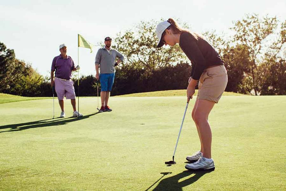 Woman taking swing at golf course