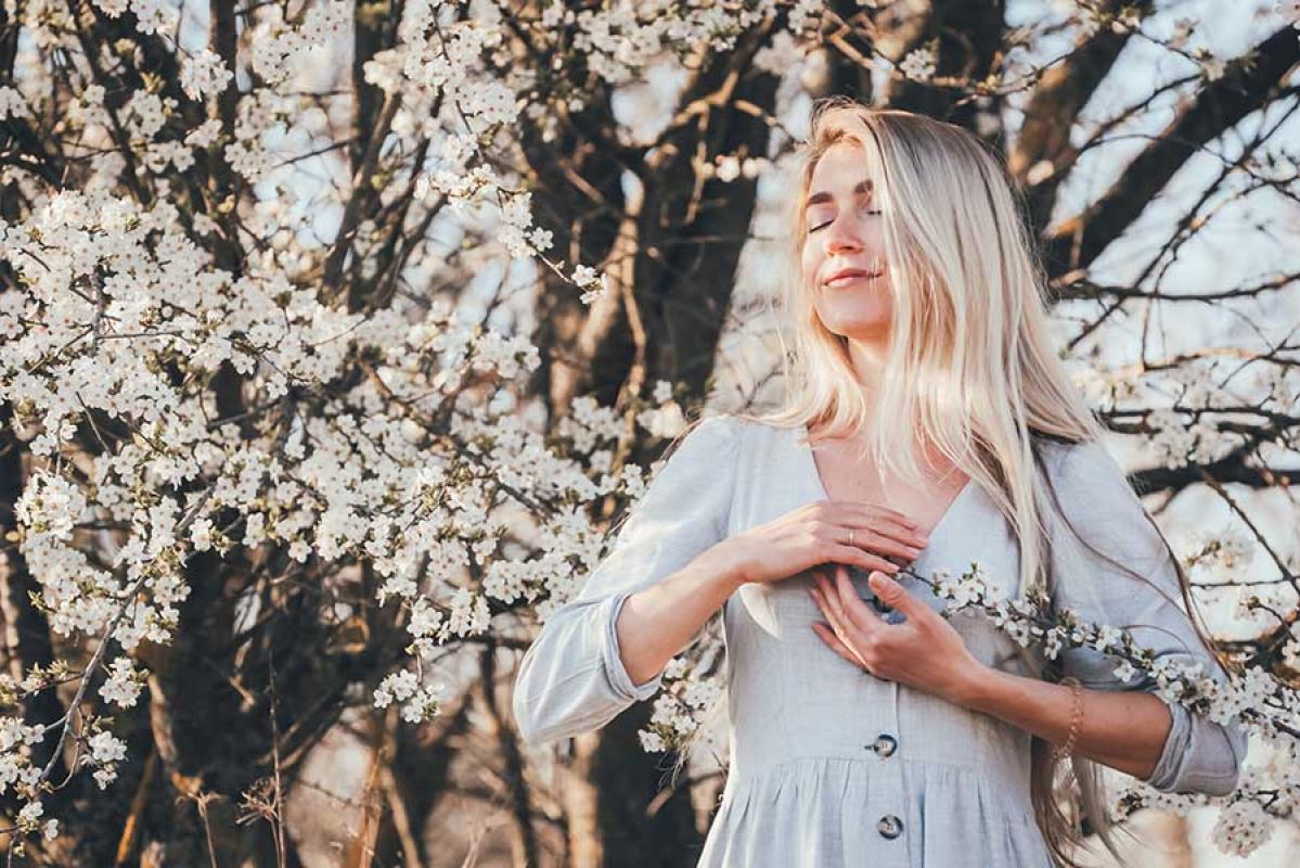 Woman breathing outside near flowers