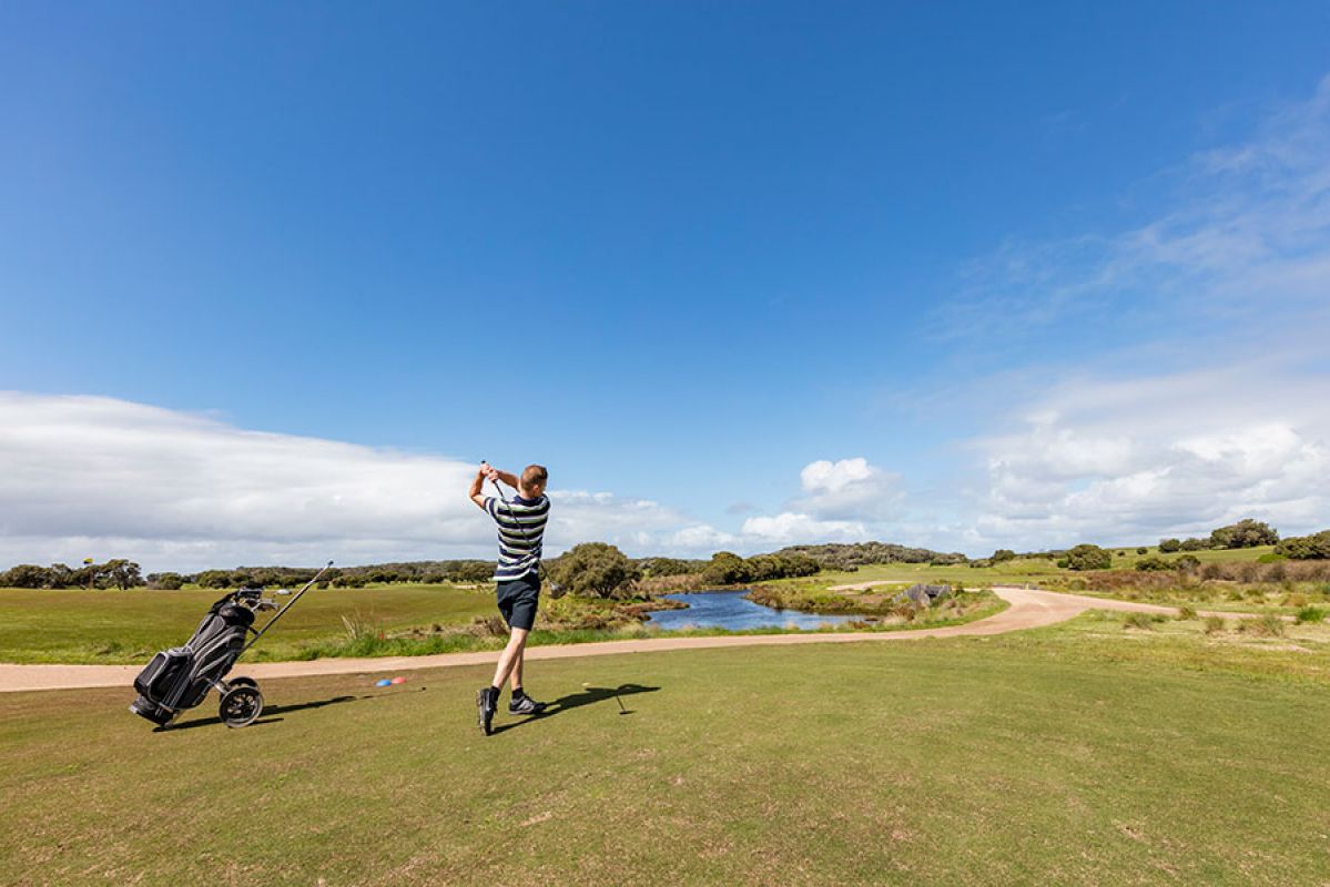 Golf player hitting driver shot on the golf course