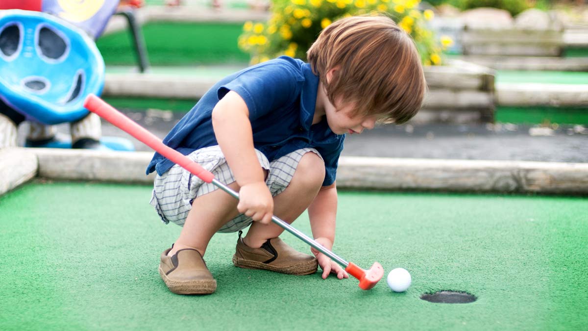 kid playing mini golf